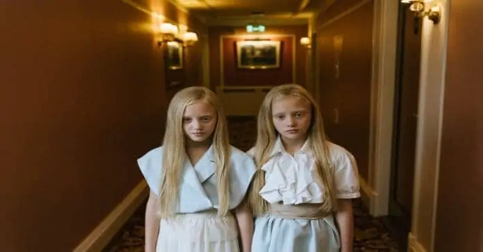 Cinematic shot of twins in a hallway.
