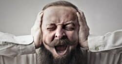 Man covering ear due to bad video audio design.