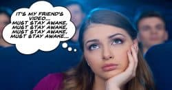 Young woman in movie theater watching a boring movie.